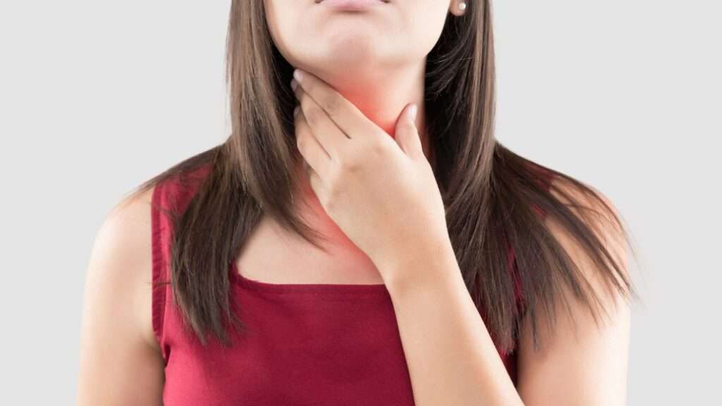 Woman holding neck to illustrate discomfort of acid reflux