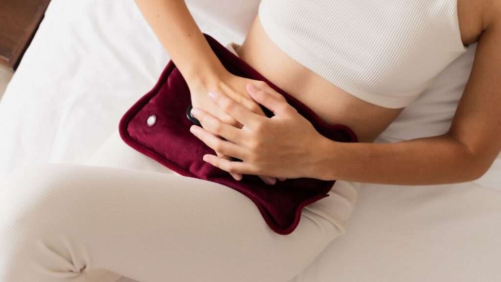 Woman in white clothes with a hot water bottle to advertise period delay treatments