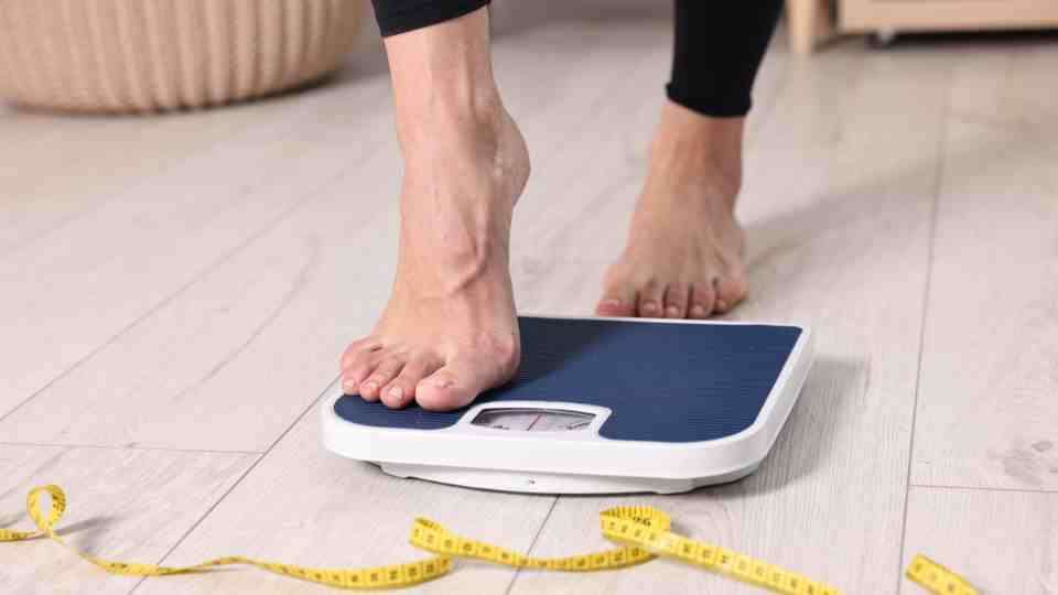 Woman on a weighing scale on a medical weight loss journey