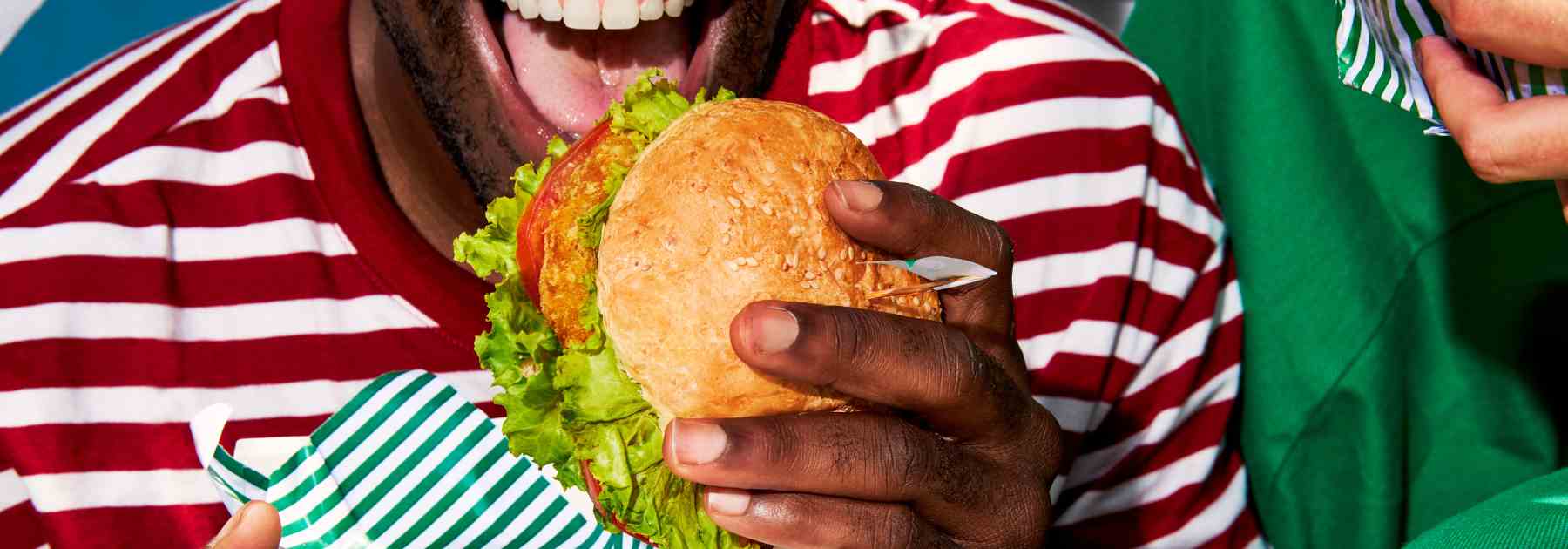 Man eating a burger and struggling to lose weight